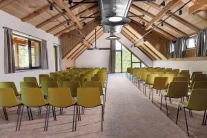 a room with rows of chairs in a building with wooden ceilings at Aldrov Resort in Vítkovice