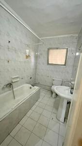 ein Badezimmer mit einer Badewanne, einem WC und einem Waschbecken in der Unterkunft Spacial place in dokki in Kairo