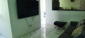 a living room with a couch and a flat screen tv at Apartamento mobiliado in Recife