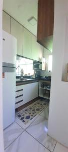 a kitchen with a white refrigerator and a sink at Apartamento mobiliado in Recife