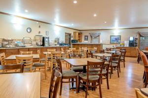 a restaurant with wooden tables and chairs and a counter at Silver Spruce Inn in Glenwood Springs