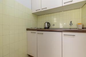 una cocina con armarios blancos y fregadero en Studio Omis 2745a en Omiš