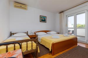 a bedroom with two beds and a balcony at Apartments with a parking space Omis - 2745 in Omiš