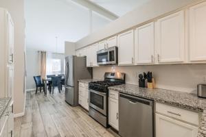 a kitchen with stainless steel appliances and a table at 4 Bedroom Near Memorial And City Centre in Houston