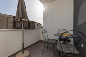 a balcony with a table and chairs and an umbrella at Apartments with a parking space Omis - 2745 in Omiš