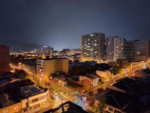 uma cidade à noite com edifícios e luzes de rua em Departamento Centro Lynch II em Temuco