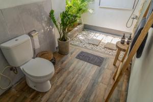 ein Badezimmer mit einem WC und einer Pflanze in der Unterkunft Sangat Indah Wooden House Uluwatu in Uluwatu + 27 Fotos