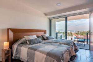 1 dormitorio con cama grande y ventana grande en Beautiful & comfortable Apt in Mexico City w/pool, en Ciudad de México