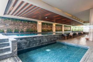 una piscina en un hotel con sillas y mesas en Beautiful & comfortable Apt in Mexico City w/pool, en Ciudad de México