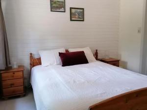 una camera con un letto bianco e un cuscino rosso di Authentic chalet in Wibrin with private fish pond a Wibrin
