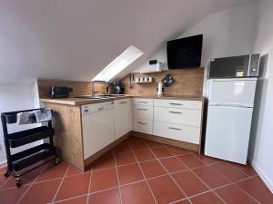 a kitchen with a white refrigerator and a sink at Cozy apartment in the Sauerland in Brilon