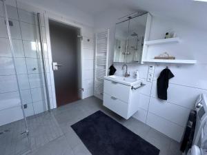 a white bathroom with a sink and a shower at Cozy apartment in the Sauerland in Brilon