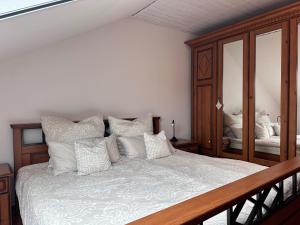 1 dormitorio con 1 cama grande con almohadas blancas en Cozy apartment with fireplace and balcony, en Brilon