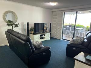 a living room with two couches and a television at Prime Position – Dream Holiday Unit in Caloundra!! in Caloundra