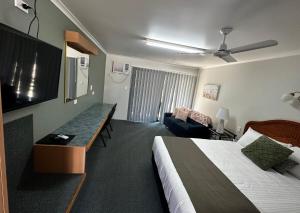 Habitación de hotel con cama y sofá en Murgon Motor Inn, en Murgon