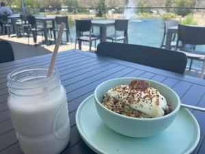 un tazón de comida y un vaso de leche en una mesa en Townsville Eco Resort 