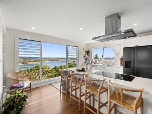 a kitchen and dining room with a view of the ocean at Lazy Days Penthouse - Opposite Shaws Bay - 180 Waterfront Views in East Ballina +14 photos