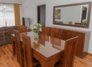 a dining room with a table with chairs and a mirror at Avenue Nuwara Eliya in Nuwara Eliya