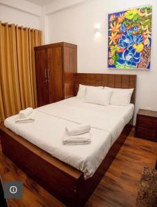 um quarto com uma cama com duas toalhas em Avenue Nuwara Eliya em Nuwara Eliya