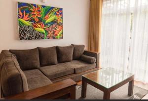 a living room with a couch and a table and a painting at Avenue Nuwara Eliya in Nuwara Eliya +13 photos