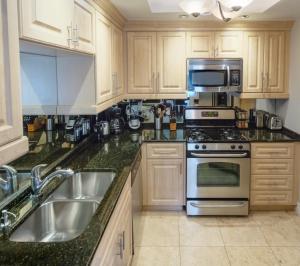 a kitchen with a sink and a stove top oven at Fabulous Penthouse Apartment LAS VEGAS Strip view with resort amenities! 5 min walk to main attractions! ONLY LONG TERM RENTALS min 31 days! in Las Vegas