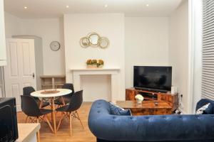 a living room with a blue couch and a table at Select SA - Queens Terrace in Reading