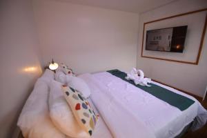 Un dormitorio con una cama blanca con un animal de peluche. en Dream Residences, en Manolo Fortich