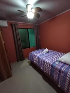 a bedroom with a bed and a ceiling fan at Arenal Palacios in Fortuna