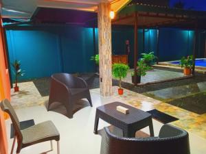 a patio with chairs and tables and a blue wall at Arenal Palacios in Fortuna