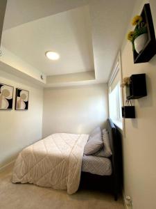 a bedroom with a bed and a window at Comfy 2BR condo in Seton, Southeast Calgary in Calgary