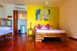 1 dormitorio con cama y pared amarilla en Tepanee Beach Resort en Malapascua Island