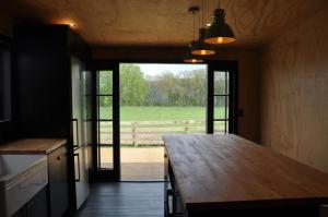 a kitchen with a wooden counter top and a large window at Renagour Cottage - Farmstay with Hot Tub! in Whanganui