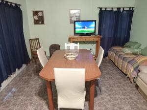 une salle à manger avec une table, des chaises et une télévision dans l'établissement La calera, à Azul