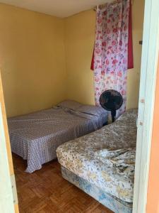 2 łóżka w małym pokoju z oknem w obiekcie Casa de playa de Solano w mieście El Tránsito