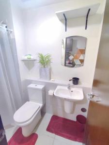a bathroom with a white toilet and a sink at My Wander Nest at Vinia Residence in Manila