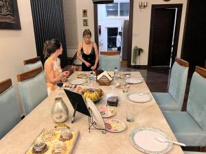 dos mujeres de pie alrededor de una mesa con comida en ella en Luxury Penthouse with Taj Mahal view en Agra