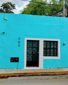 a blue building with a black door and windows at Estudio Colibrí MID - Centro Histórico Mérida in Mérida
