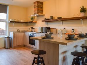 a kitchen with a counter and some stools in it at Apartment Two - Uk45353 in Southport