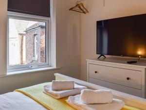 a bedroom with a tv and a bed with towels at Apartment Two - Uk45353 in Southport