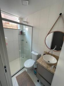 a bathroom with a toilet and a sink and a mirror at Lindo apto em condomínio top in Vitória da Conquista