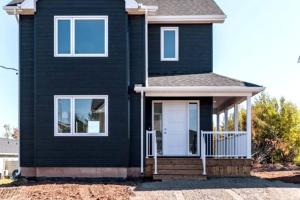 a black house with a white door at Cozy One bedroom Apartment in Moncton