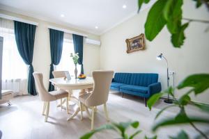 un soggiorno con tavolo, sedie e divano blu di Old Town-Booking Apartment a Tbilisi City