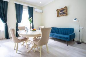 uma sala de jantar com uma mesa e um sofá azul em Old Town-Booking Apartment em Tbilisi