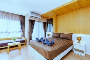 First Hua Hin - Ji Ya في هوا هين: غرفة نوم مع سرير مع الزهور الزرقاء عليه