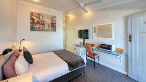 Habitación de hotel con cama y escritorio en Tumut Farrington motel, en Tumut