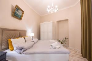 a bedroom with a large white bed with a chandelier at Old Town-Booking Apartment in Tbilisi City