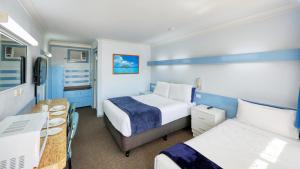 a hotel room with two beds and a desk at Tumut Farrington motel in Tumut +32 photos