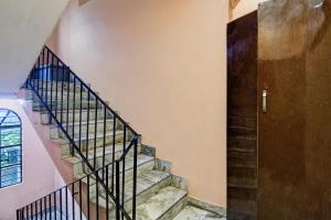 a staircase in a house with a wooden door at Super OYO Padmavati Projects Pvt Ltd Near Netaji Subhash Chandra Bose International Airport in Dum Dum