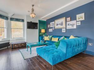 a blue living room with a blue couch at Pooley Bridge Apartment - Uk44955 in Pooley Bridge