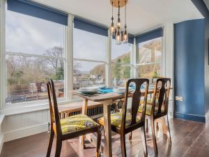 a dining room with a table and chairs and large windows at Pooley Bridge Apartment - Uk44955 in Pooley Bridge